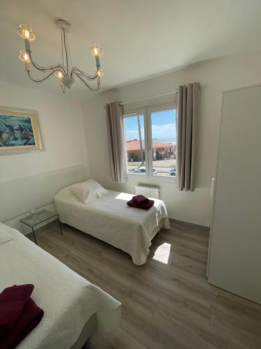 een slaapkamer met twee bedden en een raam bij la plage in Six-Fours-les-Plages