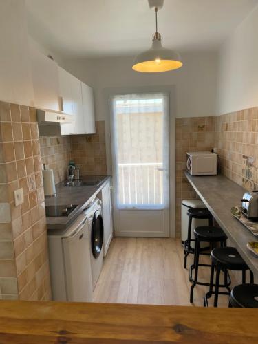 une cuisine avec un évier et un lave-vaisselle dans l'établissement la plage, à Six-Fours-les-Plages