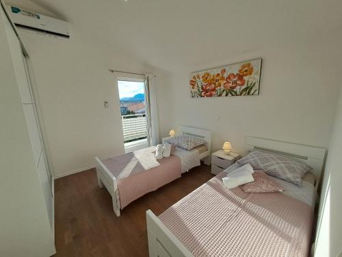 Un dormitorio con dos camas y una ventana. en luxury apartment on top floor, en Podstrana