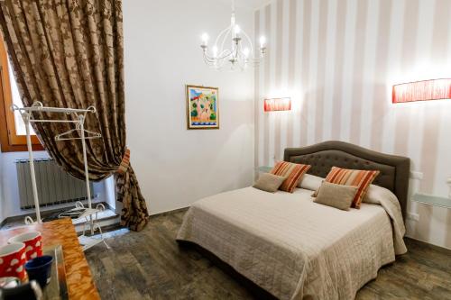 a bedroom with a bed and a chandelier at Residenza Carlandi Tivoli in Tivoli
