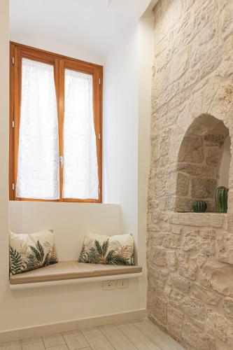 a window seat in a room with a stone wall at ANTICA MACINA Apartment in Molfetta