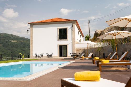 a villa with a swimming pool and a house at Quinta de Reis in Ponte da Barca