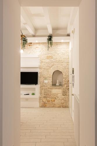 a hallway with a stone wall and a television at ANTICA MACINA Apartment in Molfetta