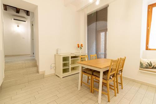 a dining room with a wooden table and chairs at ANTICA MACINA Apartment in Molfetta