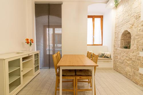 a dining room with a wooden table and chairs at ANTICA MACINA Apartment in Molfetta
