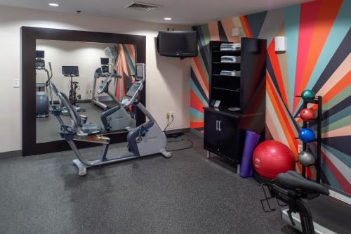 a room with a gym with exercise equipment and a mirror at Hilton Garden Inn St. Louis/Chesterfield in Chesterfield