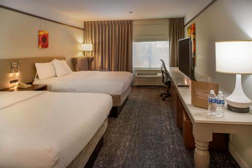 a hotel room with two beds and a desk at Hilton Garden Inn St. Louis/Chesterfield in Chesterfield