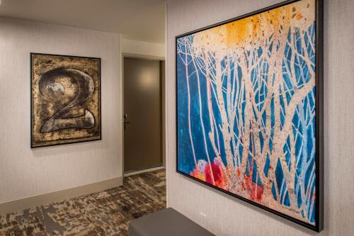 a large painting hanging on a wall in a hallway at Hilton Garden Inn St. Louis/Chesterfield in Chesterfield