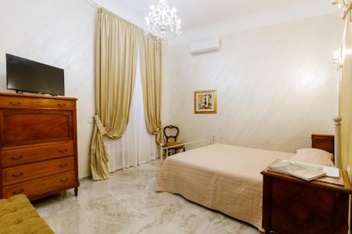 a bedroom with a bed and a dresser and a tv at Residenza Carlandi Tivoli in Tivoli