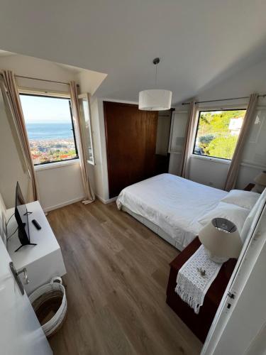 a bedroom with a bed and a large window at Home Away From Home in Funchal