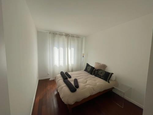 - un lit avec 2 oreillers noirs dans l'établissement Lac Zen & Frissons des JO 2024, à Épinay-sur-Seine