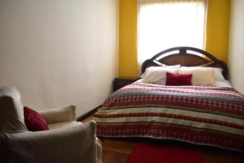 a bedroom with a bed with a blanket and a window at Raven La Paz in La Paz