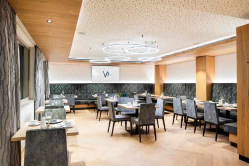a restaurant with tables and chairs and a sign that says va at Hotel B&B VILLA-ALPIN in Grossarl