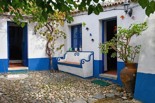 a blue and white building with a bench in front at Casa das Romãs in Salvada