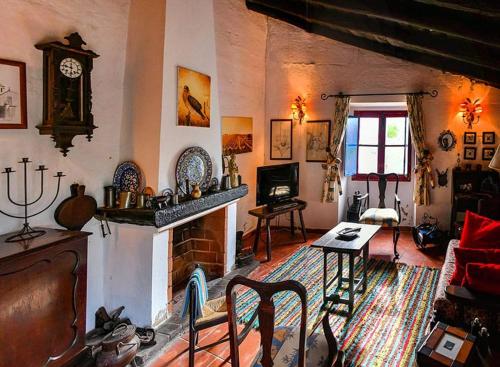 a living room with a fireplace and a couch and a table at Casa das Romãs in Salvada