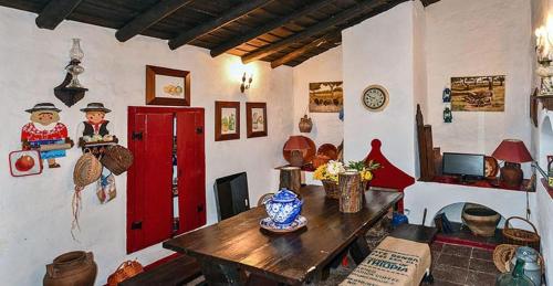 a living room with a table and a red door at Casa das Romãs in Salvada