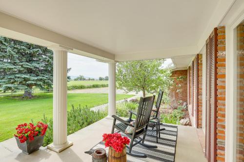 a porch with two chairs and a table with flowers at Charming Joliet Ranch House on a Working Farm in Silesia
