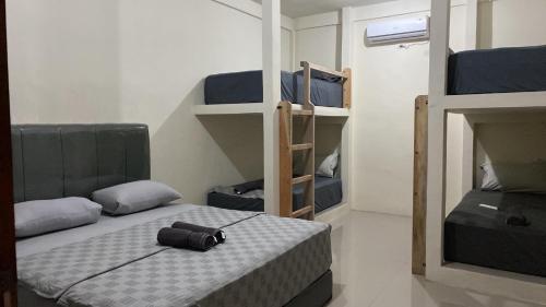 a room with two bunk beds and a bed with a pillow at Gino's Place - Guest House & Jungle Trekking in Bukit Lawang