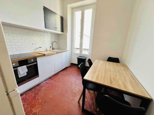 une cuisine avec une table en bois et une table et des chaises dans l'établissement Joliette, Charmant T2 , hôpital Européen 13002, à Marseille