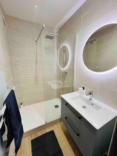 une salle de bain avec un lavabo et une douche avec un miroir dans l'établissement Joliette, Charmant T2 , hôpital Européen 13002, à Marseille