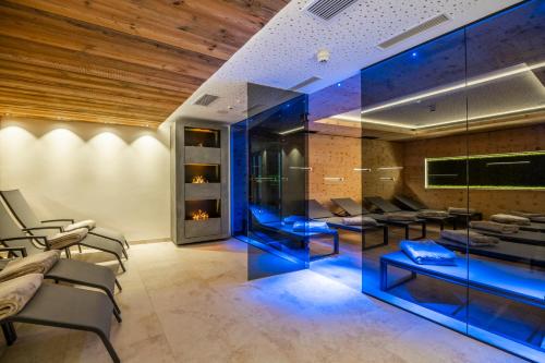 a salon with blue chairs and tables in a room at Hotel B&B VILLA-ALPIN in Grossarl