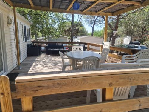 un patio avec une table et des chaises sur une terrasse dans l'établissement La Baume La Palmeraie Camping Resort, à Fréjus