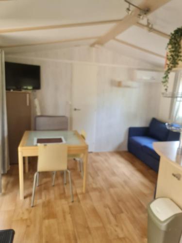 un salon avec une table et un canapé bleu dans l'établissement La Baume La Palmeraie Camping Resort, à Fréjus
