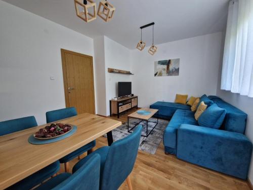 a living room with a blue couch and a table at Apartman Pavlović in Soko Banja