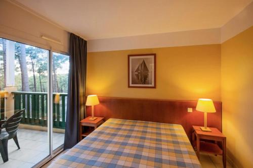 a bedroom with a bed and a balcony at Résidence Les Grands Pins - maeva Home - 2 Pièces 5 Personnes Sélection MAE-1769 in Maubuisson