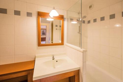 a bathroom with a sink and a mirror and a tub at Résidence Les Grands Pins - maeva Home - 2 Pièces 5 Personnes Sélection MAE-1769 in Maubuisson