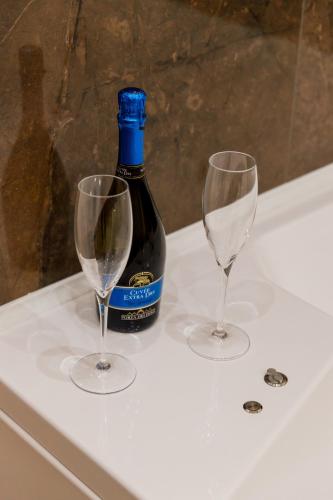 a bottle of wine and two wine glasses on a bath tub at Residenza Carlandi Tivoli in Tivoli