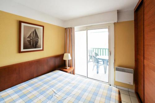 une chambre avec un lit et un balcon dans l'établissement Résidence Les Grands Pins - maeva Home - 2 Pièces 5 Personnes Sélection MAE-3316, à Maubuisson