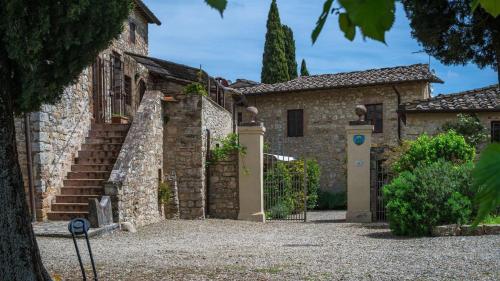 an old stone house with a gate and stairs at Bella Vista in Gaiole in Chianti