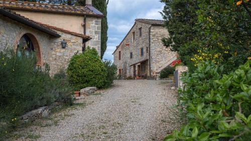 a gravel road leading to an old stone building at Bella Vista in Gaiole in Chianti