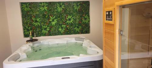 a bathroom with a bath tub with a painting on the wall at Glamour Apartman in Gyula