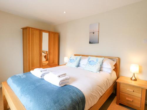 a bedroom with a bed with towels on it at Crab Corner in Wells next the Sea