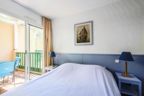 - une chambre avec un lit blanc et un balcon dans l'établissement Résidence Les Grands Pins - maeva Home - Appartement 2 Pièces 5 Personnes - Confort MAE-1502, à Maubuisson