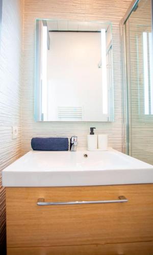 une salle de bain avec un lavabo blanc et un miroir dans l'établissement Opéra, Vieux-Port, Charmant type 2, à Marseille