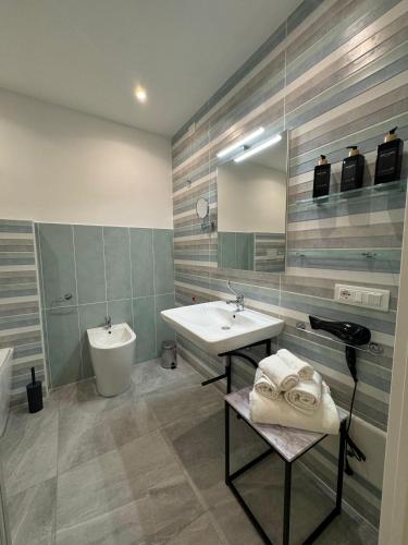 a bathroom with a sink and a toilet and a mirror at Villa Mimosa Florital - Free Private Parking On site & in Tropea in Santa Domenica