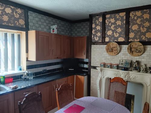 una cucina con armadi in legno, tavolo e camino di 2 hampstead Liverpool a Liverpool
