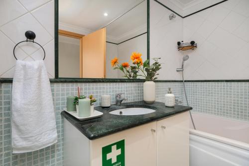 a bathroom with a sink and a mirror at Sea Lux Ericeira Beach in Ericeira