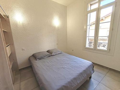 une chambre avec un lit et une fenêtre dans l'établissement Le Centre du Monde, à Perpignan