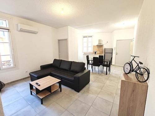 un salon avec un canapé noir et une table dans l'établissement Le Centre du Monde, à Perpignan