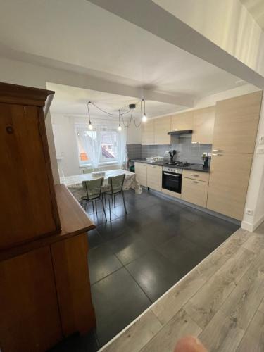 une grande cuisine avec une table et des chaises. dans l'établissement Appartement Centre Alsace, à Gertwiller