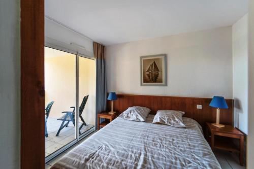 une chambre avec un lit et un balcon dans l'établissement Résidence Les Grands Pins - maeva Home - Appartement 2 pièces 4 personnes Sélection MAE-1805, à Maubuisson