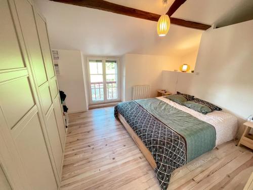 une chambre avec un lit et un parquet dans l'établissement Gite en appartement en sud ouest, à Saint-Martin-de-Hinx