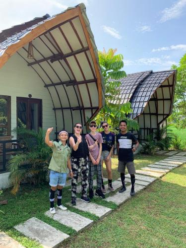 a group of people standing in front of a house at Gino's Place - Guest House & Jungle Trekking in Bukit Lawang