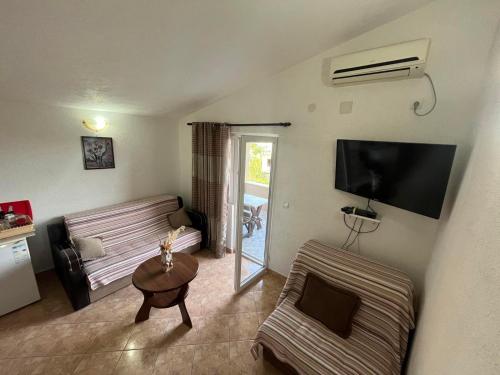 a living room with a couch and a tv at Apartmani Joca in Sutomore