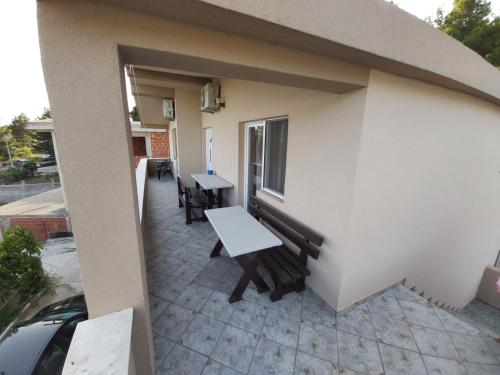 a patio with a table and benches on a building at Apartmani Joca in Sutomore
