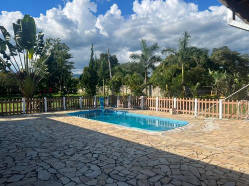 a swimming pool in a yard with a fence at Chácara Segundo Sol in Caçapava